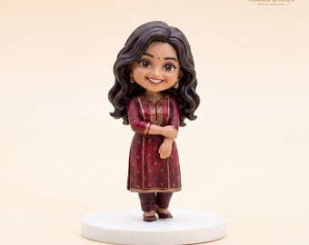 May include: A custom bobblehead figurine featuring a person with long wavy dark hair, wearing a deep maroon tunic with gold embroidery and matching pants. The figure stands on a circular white base and includes the text R&R Ribbons & Relics.