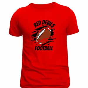 May include: A red t-shirt featuring a football graphic. The graphic includes a brown football with white laces, black accents, and the words "RED DEVILS FOOTBALL" in black text.