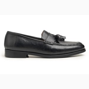Handmade black full grain leather tassel loafers for men with moc toe stitching, slip-on design, and durable rubber outsole on a white background.