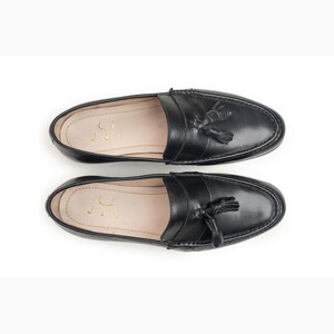 Handmade black full grain leather tassel loafers for men with moc toe stitching, slip-on design, and durable rubber outsole on a white background.