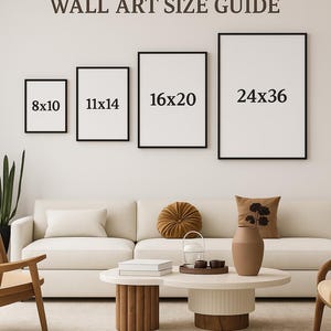 May include: A wall art size guide displays four framed prints: 8x10 inches, 11x14 inches, 16x20 inches, and 24x36 inches. The text "WALL ART SIZE GUIDE" is above the prints. The scene includes a white sofa, coffee table, and decorative items.