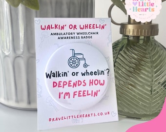 May include: A white awareness badge with the text "Walkin' or wheelin'? DEPENDS HOW I'M FEELIN'" and a wheelchair graphic. The badge is on a card that reads "WALKIN' OR WHEELIN' AMBULATORY WHEELCHAIR AWARENESS BADGE".