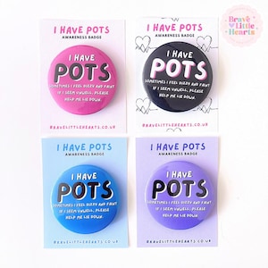May include: Four awareness badges with the text "I HAVE POTS" in white on a colored background. The badges are pink, black, blue, and purple. Each badge has the text "Sometimes I feel dizzy and faint if I seem unwell, please help me lie down."