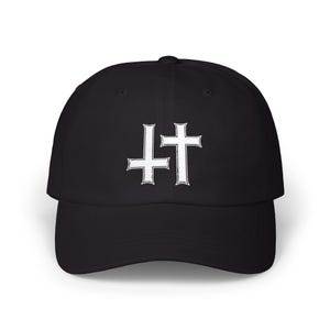May include: A black baseball cap featuring an embroidered design on the front panel. The design consists of two white cross symbols positioned side by side, with the left cross inverted and the right cross in an upright orientation.