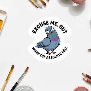 Può includere: Un adesivo bianco con un piccione dei cartoni animati con un'espressione sorpresa. Il piccione è blu, viola e grigio, con il testo "EXCUSE ME, BUT WHAT THE ABSOLUTE HELL" in nero. Pennelli, acquerelli e nastro decorativo circondano l'adesivo.