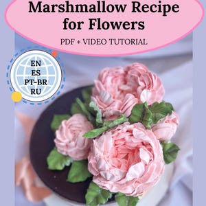 May include: A cake decorated with pink marshmallow flowers and green leaves. The cake is on a white plate with a brown base. Text on the image reads "Marshmallow Recipe for Flowers" and "PDF + VIDEO TUTORIAL".
