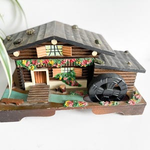 This vintage 1960s Swiss chalet-style musical jewelry box features a functioning water wheel