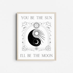 May include: Framed black and white art print featuring a yin-yang design with a sun and moon motif. The artwork includes the text "YOU BE THE SUN" and "I'LL BE THE MOON" in a decorative font, surrounded by celestial elements.