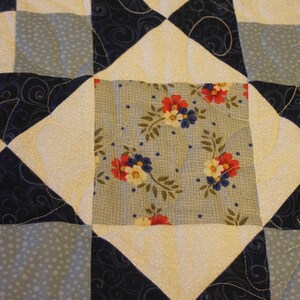 Puede incluir: Un bloque de colcha con un patr&oacute;n floral azul y blanco en el centro. El bloque est&aacute; rodeado de cuadrados blancos y azules con un patr&oacute;n de espiral.