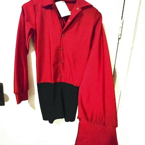 May include: A red long-sleeved shirt with a black lower section. The shirt has a collar, button-up front, and a tag attached. The sleeves are long and end in a flared cuff. The shirt is hanging on a wooden hanger.