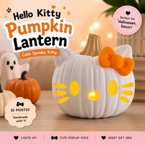 May include: A white pumpkin-shaped lantern featuring Hello Kitty facial features, including yellow oval eyes, a yellow nose, and three yellow whiskers on each side. The lantern has a tan stem and a bright orange bow attached to the side.