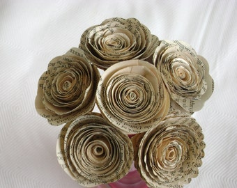 May include: A bouquet of six paper roses made from the pages of an old book. The roses are a light beige color and have a vintage look.