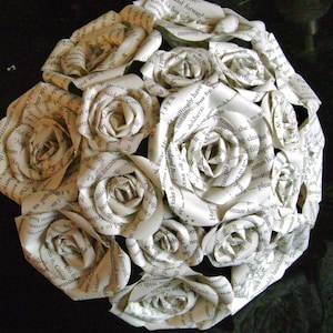Peut inclure: Un bouquet de roses blanches en papier, réalisées à partir des pages de vieux livres. Les roses sont disposées en cercle et ont un aspect vintage.