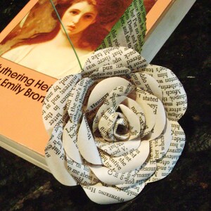 May include: A white paper flower made from pages of the book "Wuthering Heights" by Emily Bronte.