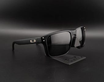 Gafas de sol polarizadas Oakley Holbrook, color negro mate con logotipo plateado.