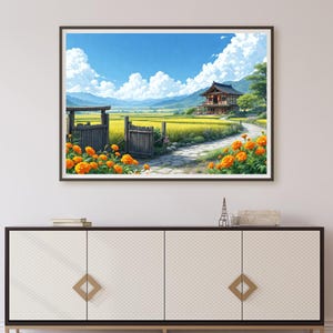 May include: Framed art print of a Japanese landscape. The artwork depicts a traditional house with a red roof, a stone path, and a field of yellow crops. Orange flowers line the path and wooden gate under a blue sky with fluffy white clouds.