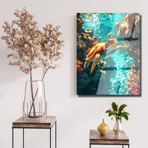Peut inclure: Impression artistique encadr&eacute;e repr&eacute;sentant une tortue de mer nageant dans un environnement sous-marin. La tortue a une carapace marron et orange avec un motif. L'arri&egrave;re-plan comprend du corail, des rochers et des bulles, avec des nuances de bleu et turquoise.