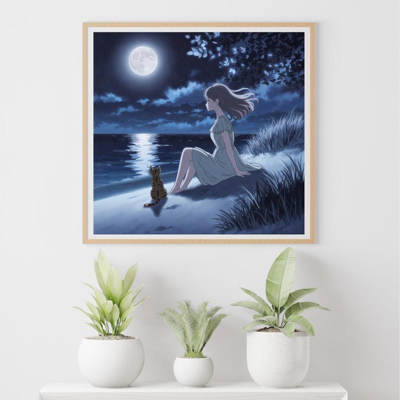 May include: A framed print shows a tranquil night scene. A person in a pale green dress sits on a sandy shore, looking at the moonlit sea. A cat is seated close by. The sky is dark blue with clouds, and the moon reflects on the water.