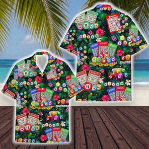 May include: Two short-sleeved button-down shirts with a tropical bingo theme. The shirts feature a dark background with bingo cards, bingo balls, and the word "BINGO" in various places. The design includes red hibiscus flowers and green leaves.