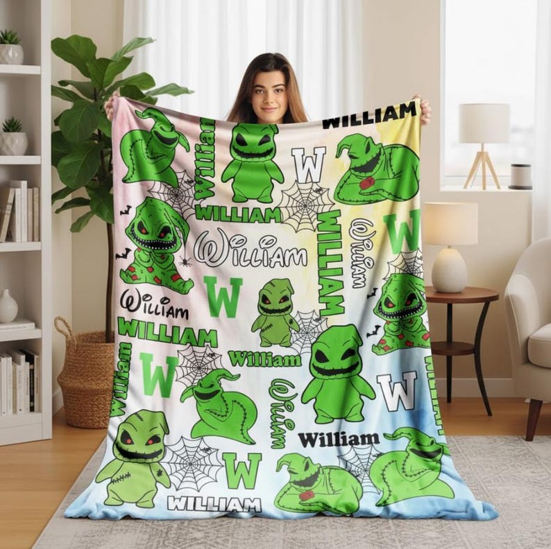 May include: A personalized blanket featuring a green cartoon character design with the name "William" and the letter "W" repeated across the surface. The blanket has a light blue, yellow, and pink gradient background, and spiderwebs are also included in the design.