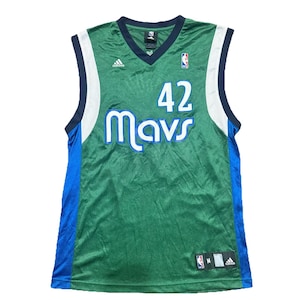 May include: Green and blue Dallas Mavericks basketball jersey with the number 42 and the word "Mavs" in white. The jersey has a V-neck and the Adidas logo. The jersey is sleeveless and has blue and white accents.