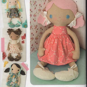 May include: Simplicity pattern for making whimsical dolls. The main doll has pink hair and a pink dress with white polka dots. Other dolls have different hair colors and dresses. The pattern includes the text "Make 'em Love 'em" and "Since 1927".