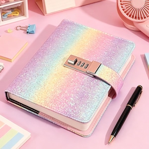 May include: A rectangular journal with a glittery, rainbow-colored cover featuring a metallic combination lock mechanism on a strap. The notebook has white pages and is accompanied by a black and gold pen resting on a pink surface.
