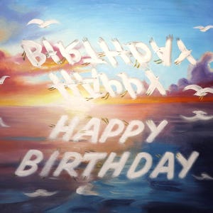 Op de afbeelding: Een artistiek schilderij van een zonsondergang boven de oceaan met de woorden "Happy Birthday" in het wit. Witte zeemeeuwen vliegen in de lucht en vormen de woorden "Happy Birthday". De lucht is een mix van oranje, roze en blauw.