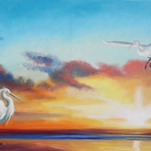 Op de afbeelding: Olieverfschilderij van een kustlandschap bij zonsondergang. Twee witte reigers zijn afgebeeld, één staand en de ander in vlucht. De lucht gaat over van blauw naar oranje en geel, wat zich weerspiegelt in het water, wat een rustige sfeer creëert.
