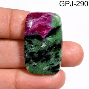 Puede incluir: Una gema rectangular con una superficie pulida. La piedra presenta una vibrante mezcla de colores, incluyendo rojo intenso, verde y negro. La parte superior es de un rojo intenso, que pasa a verde con inclusiones negras. El texto "GPJ-290" es visible.