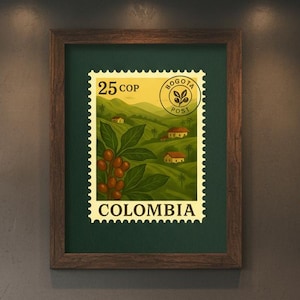 May include: A framed vintage Colombian postage stamp featuring a coffee plant with red berries, rolling green hills, and small houses. The stamp is labeled "Colombia" and "Bogota Post". The frame is brown.