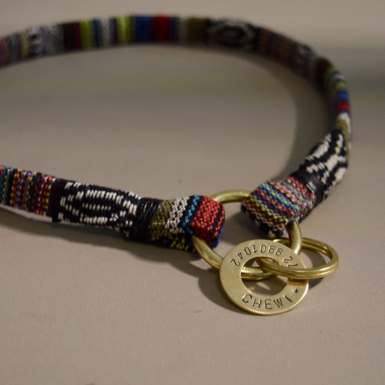 May include: A colorful woven dog collar with a brass tag that reads "866 270 22" and "CHEWI".