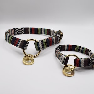 May include: Two colorful dog collars with brass D-rings and engraved tags. The collars are made of woven fabric with a black, white, red, and green striped pattern. The tags read "SINCLAIR" and "BELLA"