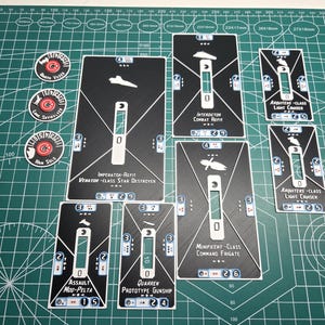 Puede incluir: Un conjunto de cartas y fichas de juego en blanco y negro, con ilustraciones de naves espaciales y texto. Las cartas incluyen nombres de naves como "Imperator-Refit" y "Arquitens-Class Light Cruiser". Las fichas tienen nombres de personajes como "Darth Vader".