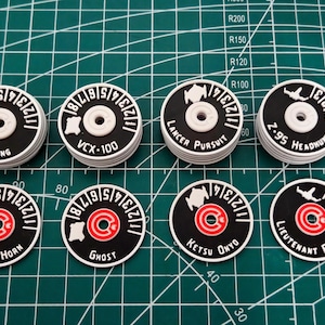 Peut inclure: Ensemble de jetons de jeu circulaires noirs et blancs. Chaque jeton présente un centre blanc et un anneau extérieur noir avec du texte et des chiffres blancs. Certains jetons ont des accents rouges.