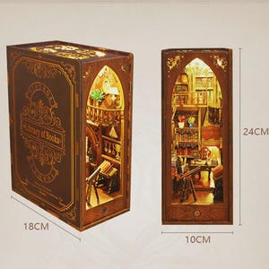 May include: A brown wooden miniature library diorama, 18cm wide and 24cm tall, with intricate interior details and warm lighting. The front features the text "Vintage Library of Books". The diorama is designed to resemble a book.