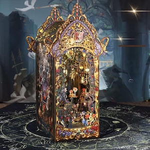 May include: An elaborate miniature house with a gothic design. It features gold, purple, and black detailing, with intricate cut-out patterns and a detailed interior scene. The house is lit, revealing a miniature world within. The overall aesthetic is ornate.