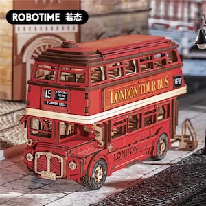 May include: A red wooden double-decker London Tour Bus model with the text "LONDON TOUR BUS" on the side. The model has detailed windows, wheels, and the number "15" on the front. The brand name "ROBOTIME" is visible.