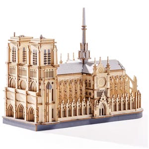 Peut inclure: Maquette en bois détaillée de la cathédrale Notre-Dame. Le modèle présente des détails architecturaux complexes, notamment des fenêtres cintrées, des flèches et une rosace. Fabriqué en bois clair, il repose sur une base grise.