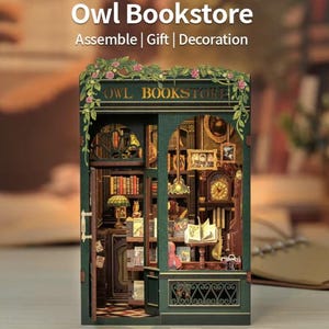 May include: A detailed miniature Owl Bookstore model. The green exterior displays the text "Owl Bookstore" and floral decorations. Inside, tiny books fill shelves, alongside a clock and lamps, creating a charming diorama. A perfect gift or decoration.
