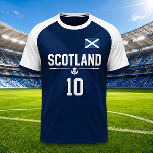 May include: A navy blue and white soccer jersey with the word "SCOTLAND" in white block letters. The number "10" is below the word. The Scottish flag is on the upper chest.