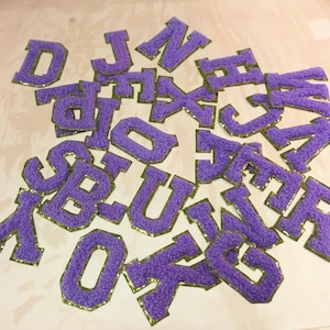 Parche de aplique con letras bordadas de chenilla brillante de la A a la Z, para planchar en chaquetas, camisetas y mochilas. Bordado con borde dorado y nombre en mayúsculas.