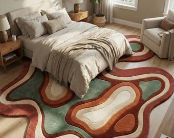 May include: A bedroom scene featuring a large, abstract rug with a wavy, layered design. The rug incorporates shades of red, green, orange, and cream. The room includes a bed with neutral-toned bedding, side tables, and a potted plant, creating a cozy atmosphere.