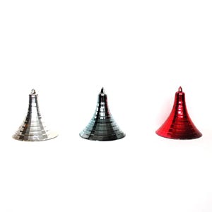 May include: Three metallic Christmas tree ornaments in silver, gray, and red. Each ornament has a conical shape with a small loop at the top for hanging. The ornaments are displayed against a white background.