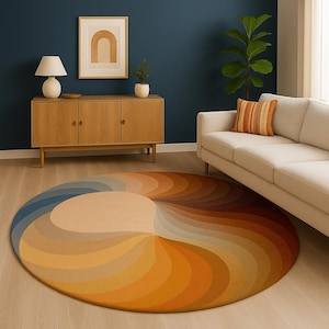 Op de afbeelding: Een ronde vloerkleed met een spiraalvormig ontwerp in tinten blauw, beige, oranje en bruin. Het vloerkleed ligt op een houten vloer in een kamer met een bank, kast en kunstwerken. Het ontwerp creëert een warme en uitnodigende sfeer.