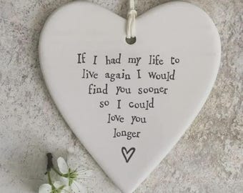 May include: A white heart-shaped ceramic ornament with a string for hanging. The ornament has the text "If I had my life to live again I would find you sooner so I could love you longer" and a heart symbol. Small white flowers are at the bottom.