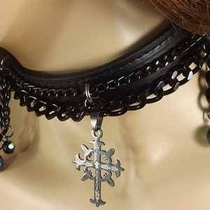 May include: Black leather choker necklace with a silver cross pendant and black crystal beads.