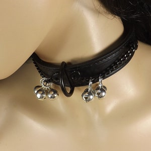 May include: Black leather choker with a silver chain and multiple silver bells.