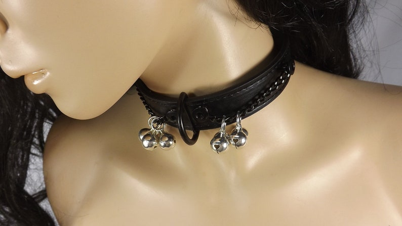May include: Black leather choker with a silver chain and multiple silver bells.
