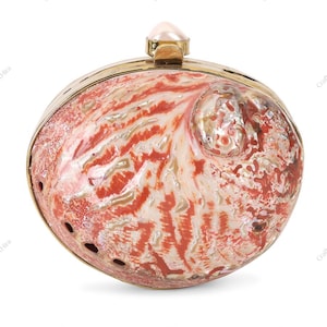 Pode incluir: Embreagem oval com exterior de concha natural, apresentando tons de vermelho, branco e bege. Possui uma moldura de metal dourado e um fecho em forma de pérola. A superfície da concha apresenta um padrão orgânico único.